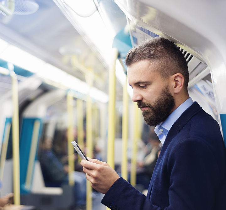 Man in suit on cellphone while on public light rail. 