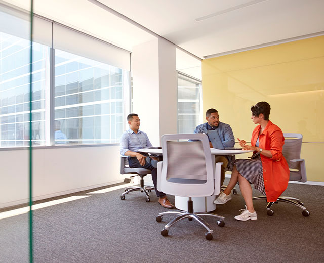 Multiple people in a conference room having a meeting.